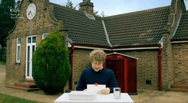 Image of Josh Widdicombe, sat at a table in the Taskmaster house garden, discovering from a task brief that he has to now count the hoops in a tin of spaghetti hoops.