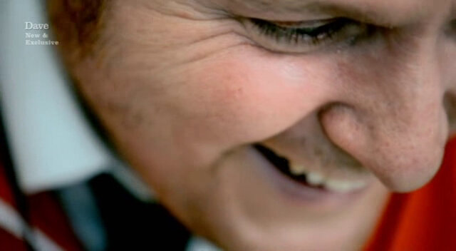 Close-up image of Tim Key laughing, when he should be crying, due to some powerful art he has experienced.