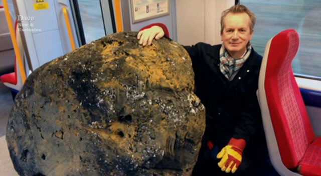 Image of Frank Skinner posing next to his prop boulder on the train from Chiswick to Feltham.