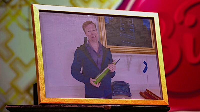 Image of the prize up for grabs in this episode: a framed photo of Johan Glans holding the Kristallen 2019 award won by the show, taken during his attempt at the first task.