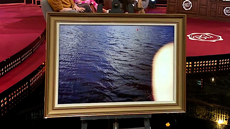 Image of the prize in this episode: a framed copy of Nour’s botched photo from the ‘Photograph the lake monster’ task. 