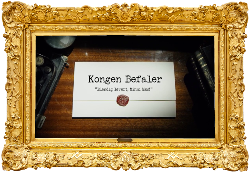 Image of the title card at the start of this episode, showing a task brief with the show title, 'Kongen Befaler', and the episode title, 'Elendig levert, Minni Mus!' ['Miserably delivered, Minnie Mouse!'], on a wooden desk. At the edges of the image, part of a typewriter keyboard and a stack of leather-bound books can be seen.