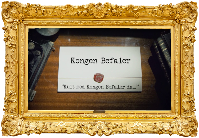 Image of the title card at the start of this episode, showing a task brief with the show title, 'Kongen Befaler', and the episode title, 'Kult med Kongen Befaler da...' ['Cool to be back with Kongen Befaler then...'], on a wooden desk. At the edges of the image, part of a typewriter keyboard and a stack of leather-bound books can be seen.