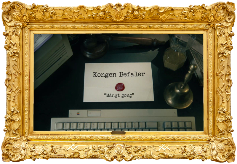 Image of the title card at the start of this episode, showing a task brief with the show title, 'Kongen Befaler', and the episode title, 'Mångt gong' ['Meny taimes'], on a wooden desk. Also on the desk is an old-fashioned Apple computer and keyboard, a gavel, an hourglass, and a bell.