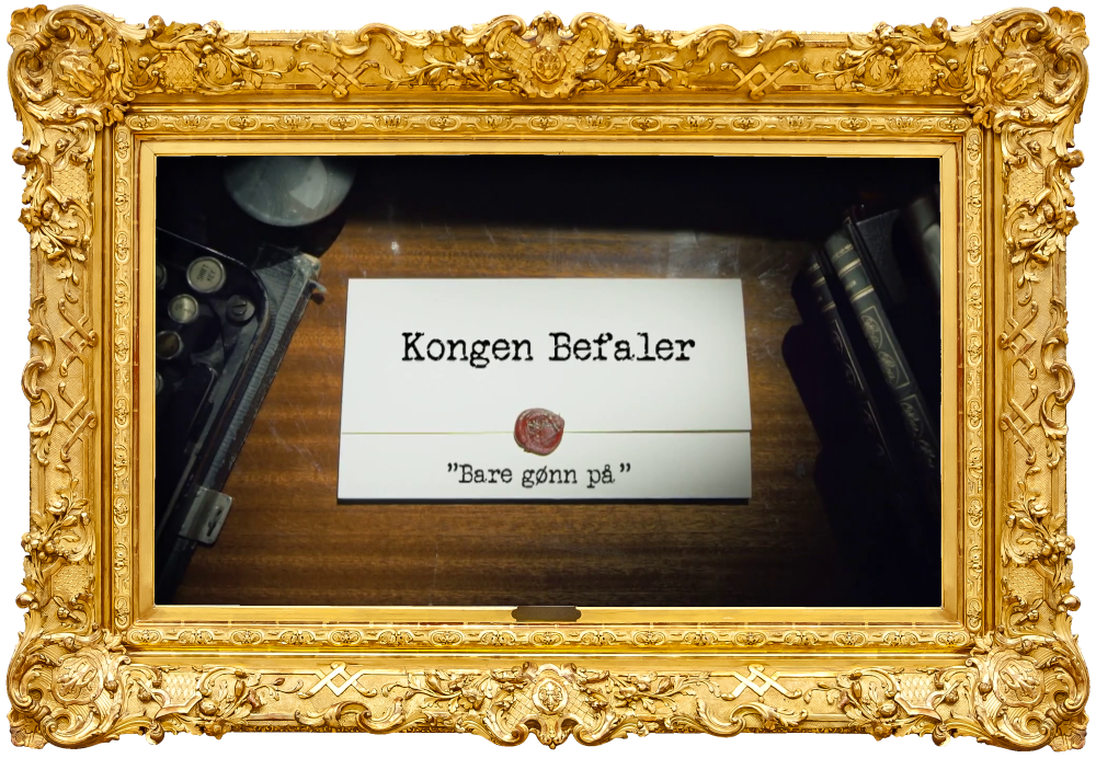 Image of the title card at the start of this episode, showing a task brief with the show title, 'Kongen Befaler', and the episode title, 'Bare gønn på' ['Just go for it'], on a wooden desk. At the edges of the image, part of a typewriter keyboard and a stack of leather-bound books can be seen.