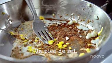 Image of a frying pan with burnt-on egg stuck to the bottom, and a fork (taken during the 'Quickly eat an egg' task), with the episode title, 'Un pied de sel' ['A foot of salt'] superimposed over the top.