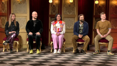 Image of the panel of contestants seated on stage together during this episode.