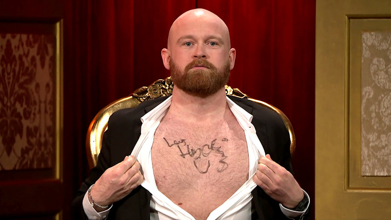 Image of Mark Le Fêvre opening up his shirt to reveal the Lars Hjortshøj autograph written on his chest.