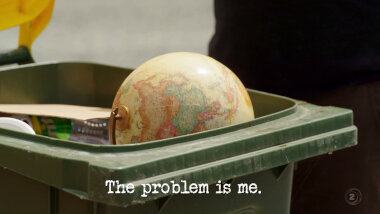 Image of a globe in the top of an open recycling bin (a reference to Leigh's attempt at the 'Make a large object vanish' task), with the episode title, 'The problem is me', superimposed on it.