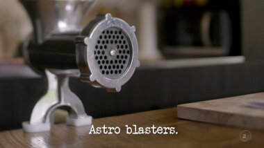 Image of the nozzle of a meat grinder (a reference to the 'Make a surprisingly pleasant sausage' task), with the episode title, 'Astro Blasters', superimposed on it.