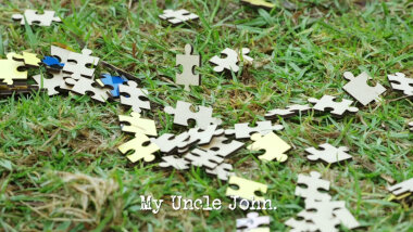 Image of the pieces of a jigsaw puzzle, scattered across a lawn (a reference to the 'Score 10 points while handcuffed' task), with the episode title, 'My uncle John', superimposed on it.