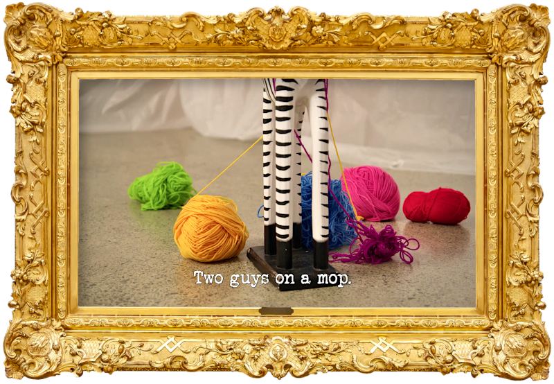 Image of the lower half of a wooden zebra statue with balls of yarn in various colours hanging from it, on the floor of the lab (a reference to Jackie van Beek's attempt at the 'Take the most mind-blowing photo' task), with the episode title, 'Two guys on a mop', superimposed on it.