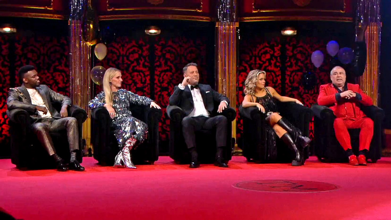 Image of the cast of the special seated together on stage.