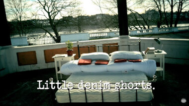 Image of an unmade double bed and nightstands in a bandstand (taken during the 'Make a bed while holding hands' task), with the episode title, ‘Little denim shorts’, superimposed on it.