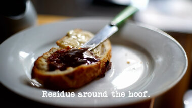 Image of a piece of heavily-Marmited toast on a plate, with a knife (a reference to the 'Make marmite' task), with the episode title, 'Residue around the hoof', superimposed on it.