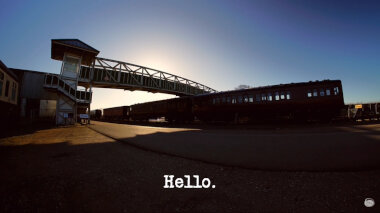 Image of a footbridge over a railway line at the Buckinghamshire Railway Centre (a reference to the 'Sneak up on Alex' task), with the episode title, 'Hello', superimposed on it.