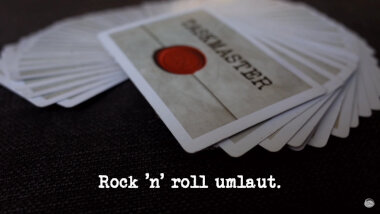 Image of the custom deck of Taskmaster themed playing cards featured in the 'Recall the order of the deck of cards' task, with the episode title, 'Rock ‘n’ roll umlaut', superimposed on it.