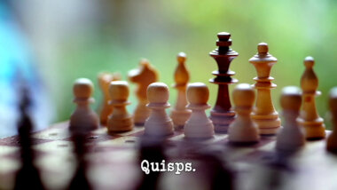 Image of a chessboard, set up for a game of chess (presumably a reference to the 'Bring a classic board game to life' task), with the episode title, 'Quisps', superimposed on it.