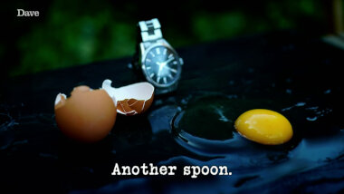Image of the two halves of an egg shell, a wristwatch, and the contents of the egg, on a smooth black surface (a reference to the 'Make an accurate and inventive egg timer' task), with the episode title, 'Another spoon', superimposed on it.
