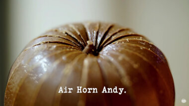 Image of an unwrapped Chocolate Orange (a reference to the 'Complete the most tasks behind the five motorised doors' task), with the episode title, 'Air Horn Andy', superimposed on it.