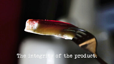 Image of a crab stick on a fork (a reference to Desiree's attempt at the 'Write and perform a 30-second jingle' task), with the episode title, 'The integrity of the product', superimposed on it.