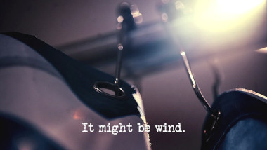 Image of the top edge of a shower curtain, and its rail (a reference to the 'Poke a body part out of the shower curtain' task), with the episode title, 'It might be wind', superimposed on it.