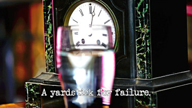 Photo of a pint of water (a reference to the 'Fill the glass up to the line' task) in front of a carriage clock, with the episode title, 'A yardstick for failure', superimposed on it.