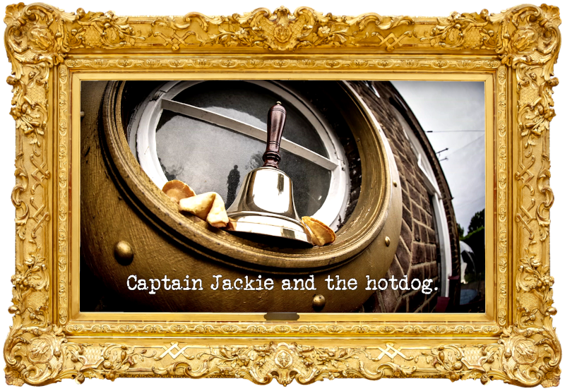 Photo of a handbell and some fortune cookies resting in the porthole frame of one of the round windows at the front of the Taskmaster house (referencing the 'Ring the bell' and 'Eat and obey five fortune cookies' tasks), with the episode title, 'Captain Jackie and the hotdog', superimposed on it.