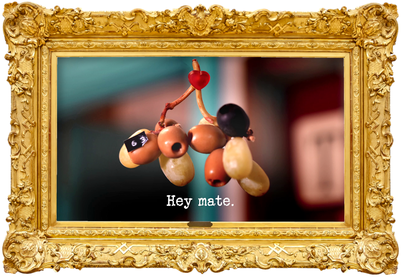 Photo of a sprig of grape stems suspended from the ceiling with both grapes and olives attached to it, as well as a small red heart and a label with the number '63' on it (referencing the 'Find out what number Alex has written down', 'Make a love heart with your team', and 'Win the horse race' tasks), with the episode title, 'Hey mate', superimposed on it.