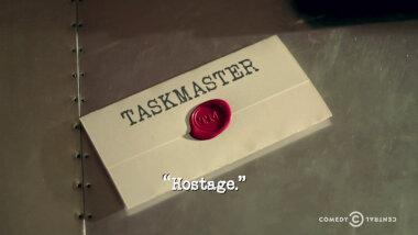 Image of a task brief laid on a metallic surface, with the episode title, 'Hostage', superimposed on it.