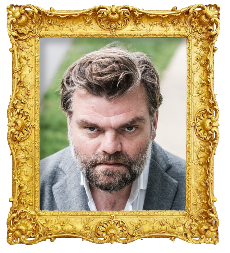 Headshot photo of Stefaan Degand surrounded with an ornate golden frame.