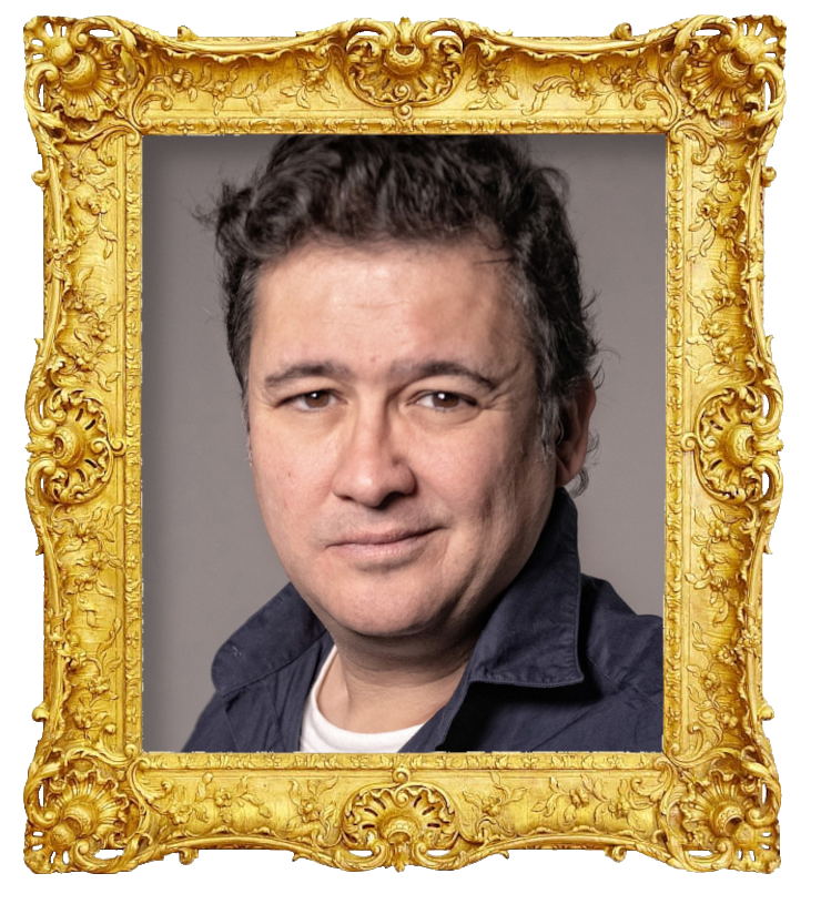 Headshot photo of Secun de la Rosa surrounded with an ornate golden frame.