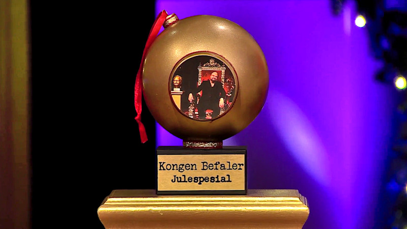 Image of the Kongen Befaler Christmas Special 2022 prize, a large golden bauble featuring a picture of Atle Antonsen on his throne.