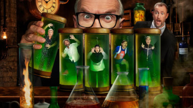 Cover image for the nineteenth series of Taskmaster UK, depicting the contestants trapped within flasks of green liquid, while a giant Greg Davies toys with them in his mad scientist laboratory, and Alex looks on in shock from behind.