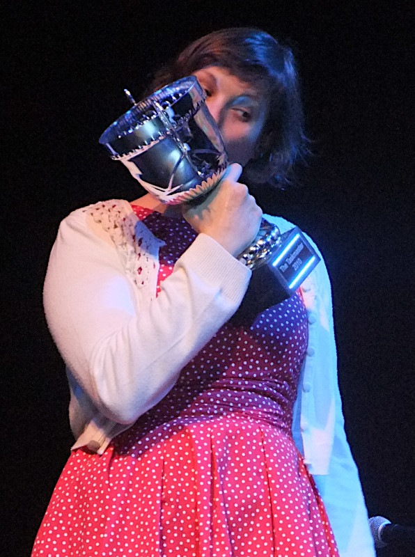 Photo of Josie Long, the winner of the second Taskmaster competition, kissing her trophy. [Credit: Isabelle (https://www.flickr.com/photos/diamondgeyser/)]