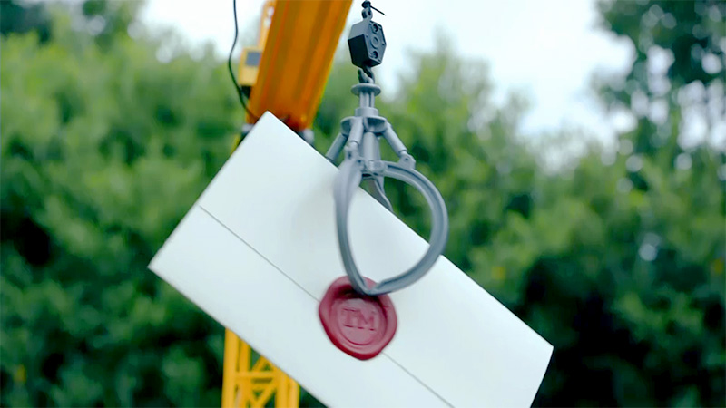 Sealed task brief held by a toy crane.
