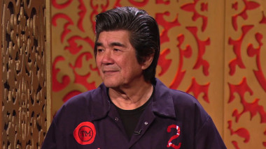 Pat wearing a Taskmaster boiler suit with a two on it.