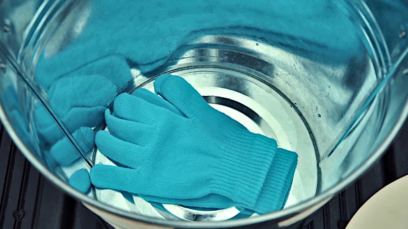 A top-down view of one of the buckets, containing a pair of knitted gloves. A top-down view of one of the buckets, containing a pair of knitted gloves.