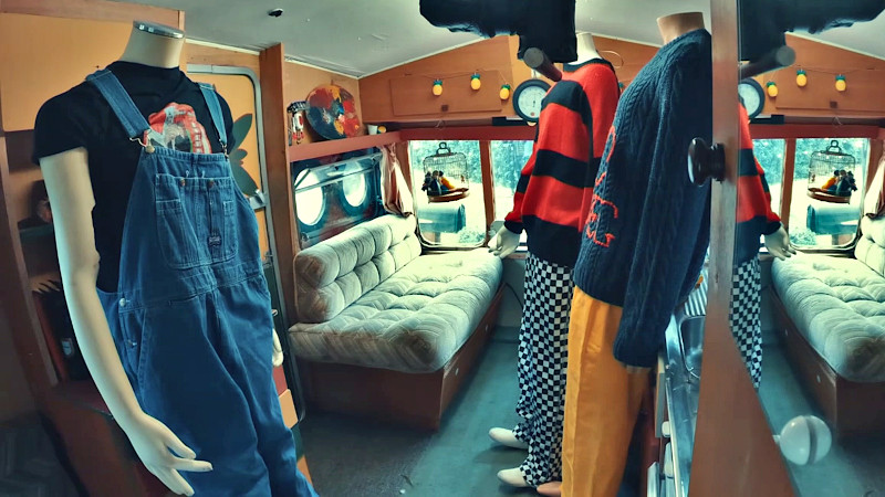 Three mannequins fully dressed in outfits for cool weather, stood in the caravan.