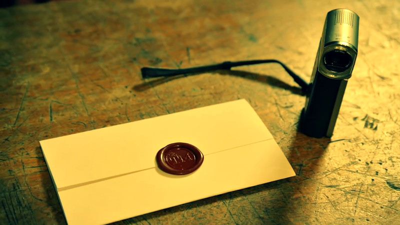 The task envelope placed next to a home video camera.